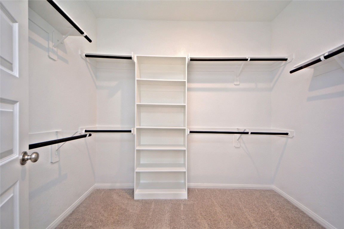 1015 Modesto Drive Rosharon, TX 77583 - Photo 19 of 37 Massive walk-in closet in the primary suite featuring built in shelving and ample hanging space for all your storage needs! Stay organized with ease in this thoughtfully designed closet that truly completes the primary retreat. This is only one side of this massive walk in closet!