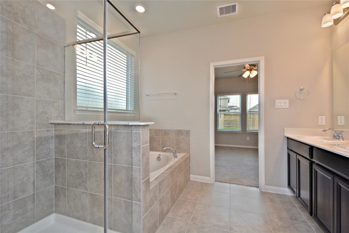 1015 Modesto Drive Rosharon, TX 77583 - Photo 20 of 37 Spa like primary bathroom featuring elegant finishes, soaking tub, and a large separate seamless glass enclosed shower! Enjoy a bright and airy space designed for relaxation and everyday luxury. A true retreat within your home!