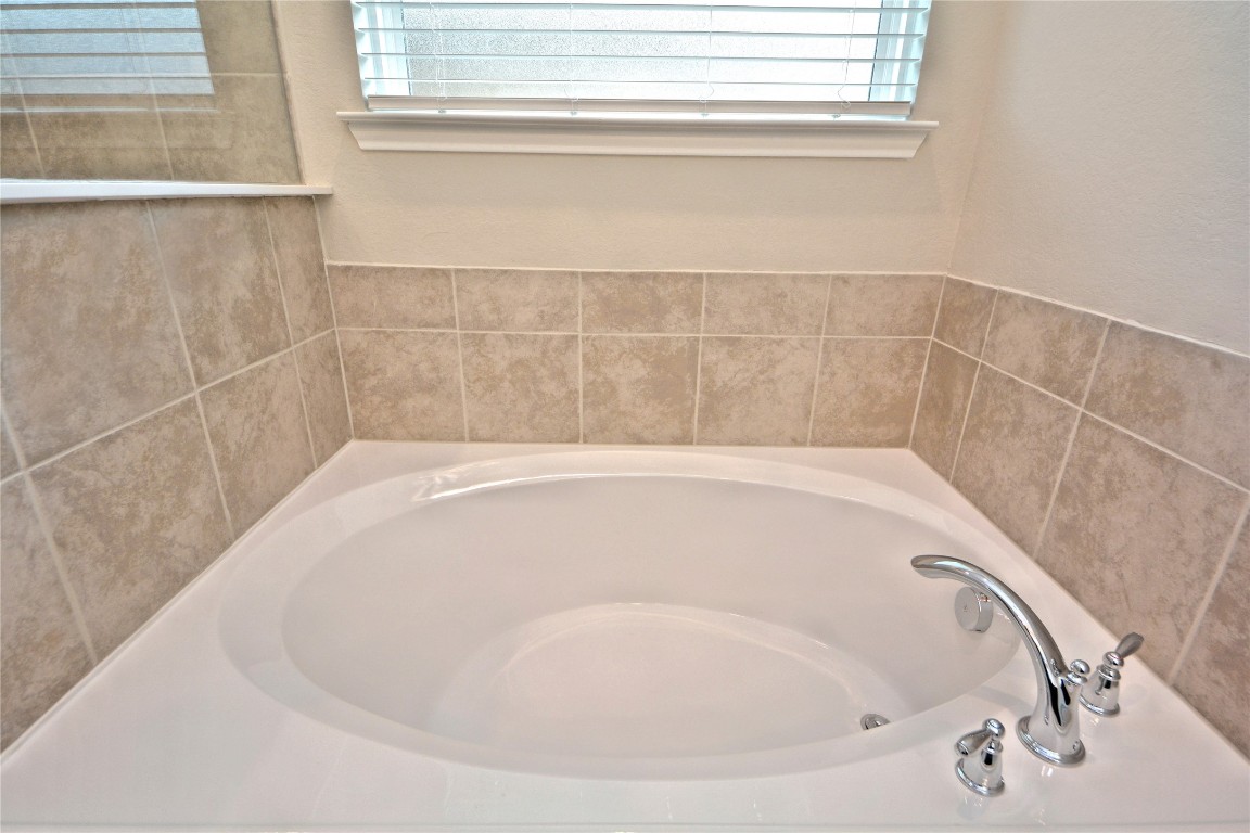 1015 Modesto Drive Rosharon, TX 77583 - Photo 21 of 37 Relax and unwind in the soaking tub surrounded by beautiful tile work, perfect for peaceful evenings and self-care moments! This luxurious feature adds comfort and style to your daily routine. Bubble away that stress!
