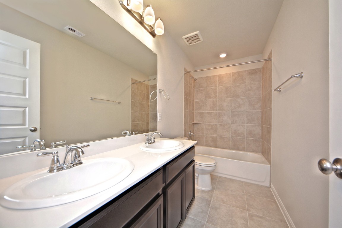 1015 Modesto Drive Rosharon, TX 77583 - Photo 29 of 37 Well appointed secondary bathroom with dual sinks, extended vanity space, and a tub and shower combo! Designed for both style and functionality to accommodate family and guests with ease.
