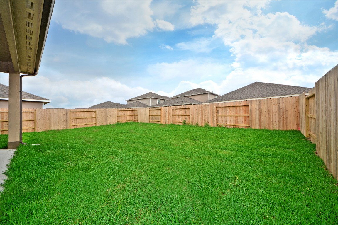 1015 Modesto Drive Rosharon, TX 77583 - Photo 32 of 37 Step outside to your expansive backyard with plenty of green space, fully fenced for privacy and equipped with a sprinkler system for easy maintenance! Perfect for entertaining, pets, playtime, or creating your dream outdoor oasis.