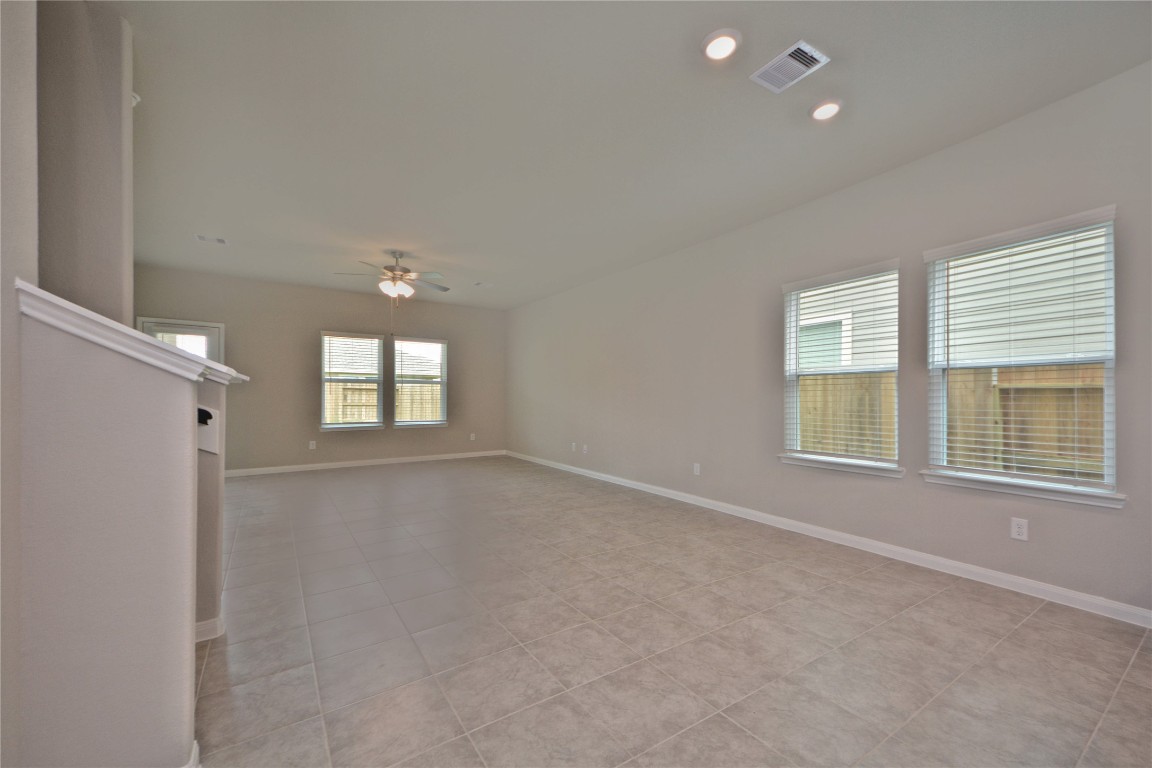 1015 Modesto Drive Rosharon, TX 77583 - Photo 8 of 37 Spacious open concept living and dining area filled with natural light and beautiful tile flooring throughout! This expansive space offers endless possibilities for furniture placement and entertaining, creating a warm and welcoming atmosphere for family and guests.