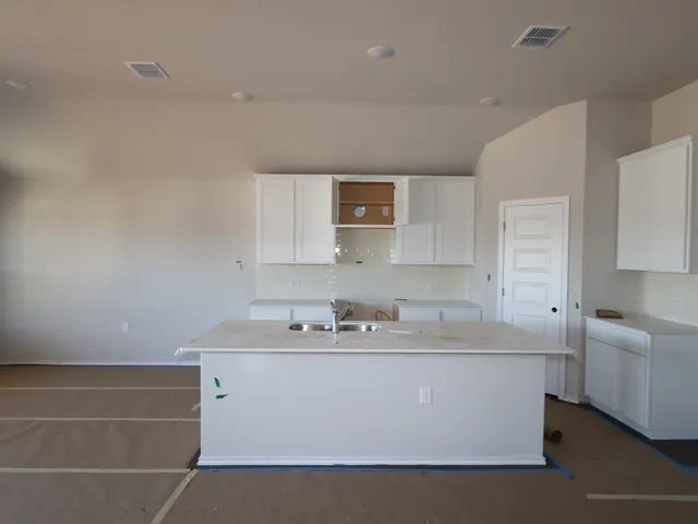 a room with a sink a mirror and cabinets
