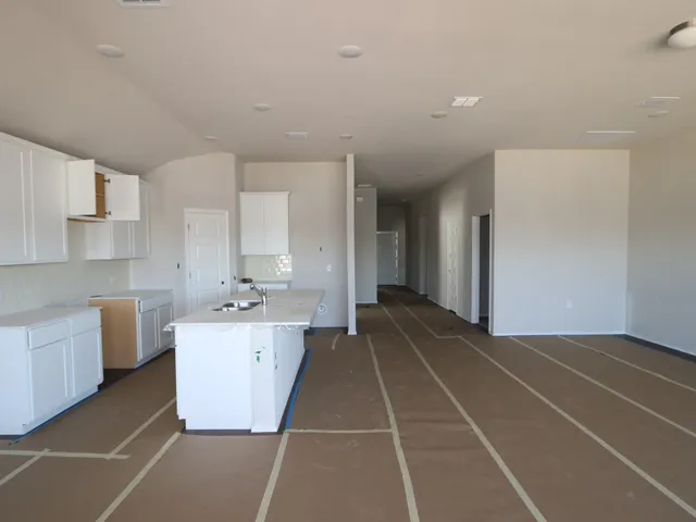 a large kitchen with stainless steel appliances a sink a stove a refrigerator and cabinets