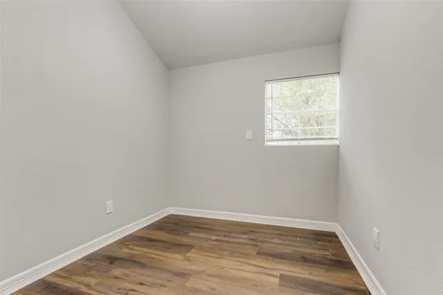 a view of an empty room with wooden floor