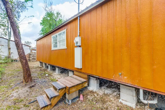 a blue house with tall trees in the background