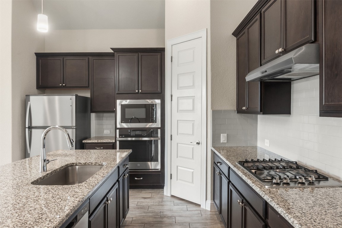 2229 Base Burner Path Leander, TX 78641 - Photo 4 of 40 a kitchen with stainless steel appliances granite countertop a sink stove and refrigerator