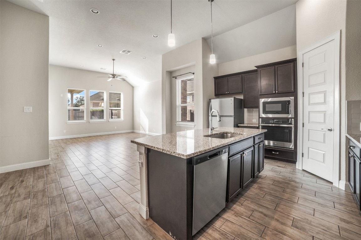 2229 Base Burner Path Leander, TX 78641 - Photo 5 of 40 a kitchen with stainless steel appliances granite countertop a stove a sink and a refrigerator