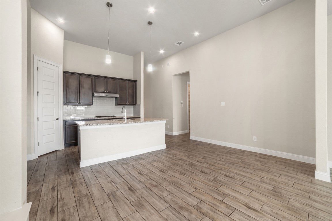 2229 Base Burner Path Leander, TX 78641 - Photo 9 of 40 a large kitchen with stainless steel appliances kitchen island a large counter top and a stove top oven