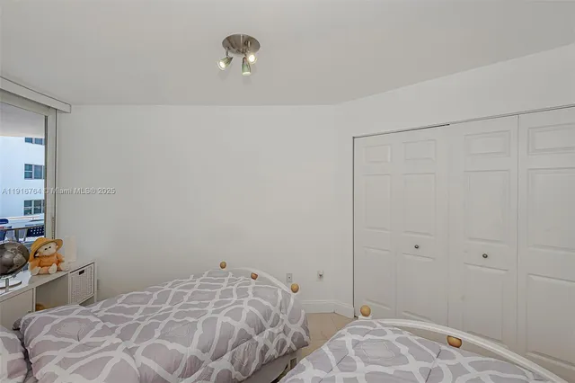 a bedroom with two beds and a lamp on the dresser