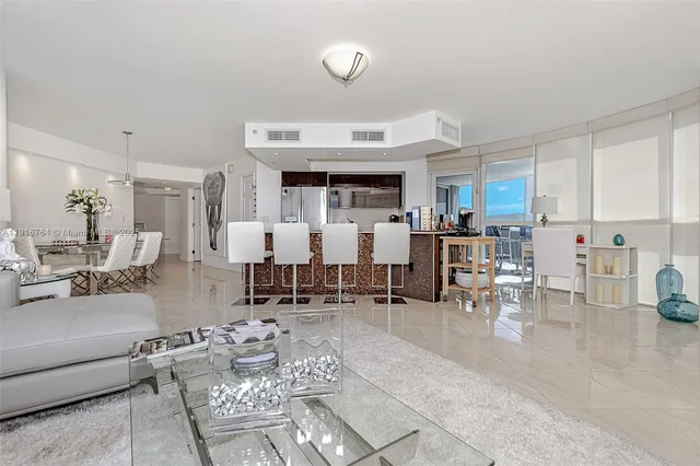 a living room with lots of furniture and view of kitchen