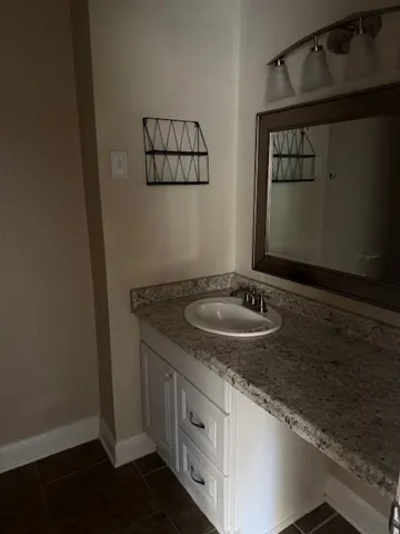a bathroom with a granite countertop sink and a mirror