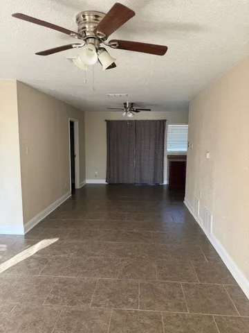 a view of a livingroom with a ceiling fan and entryway