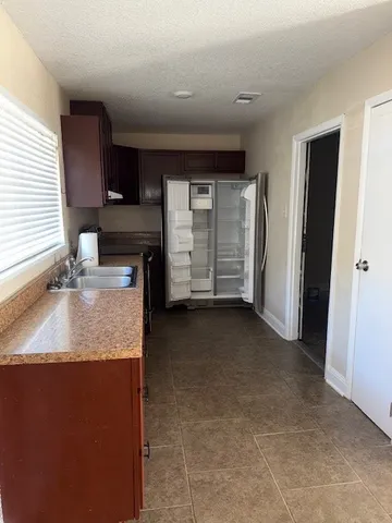a kitchen with granite countertop a sink a stove and cabinets