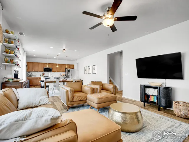 a kitchen with stainless steel appliances granite countertop a stove top oven a refrigerator a sink and chairs