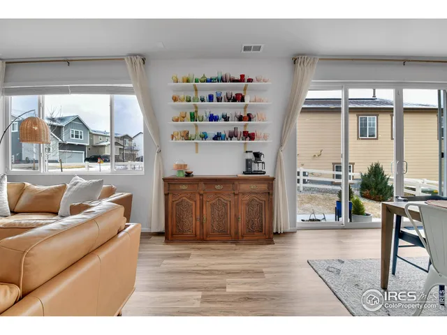 a kitchen with stainless steel appliances granite countertop a dining table chairs refrigerator and microwave