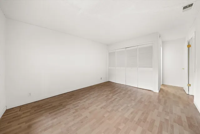 an empty room with wooden floor and white walls