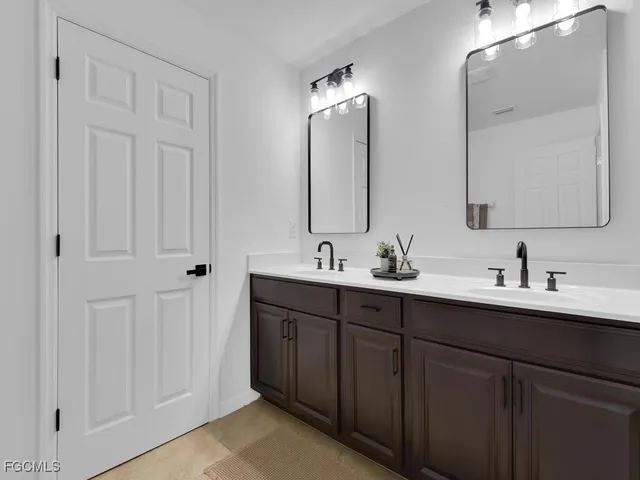 a bathroom with double vanity sinks and a mirror