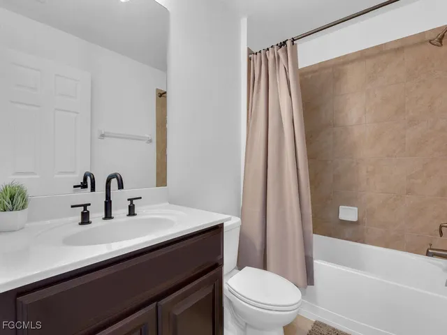 a bathroom with a sink a toilet a tub and shower