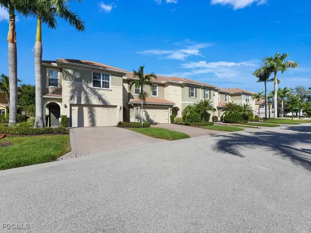 a view of a house with a yard and palm trees