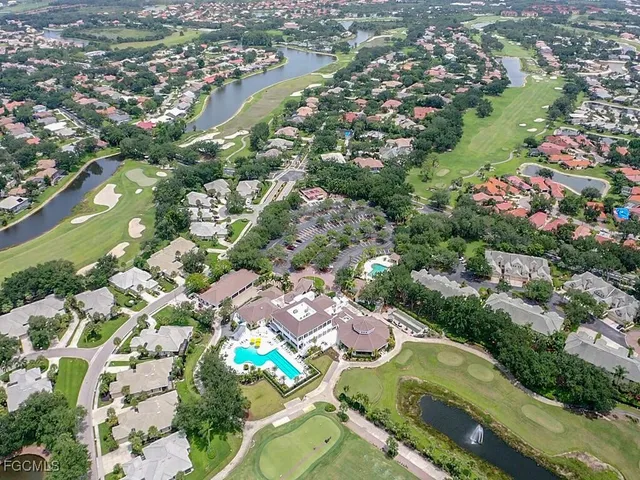 an aerial view of residential houses with outdoor space and trees