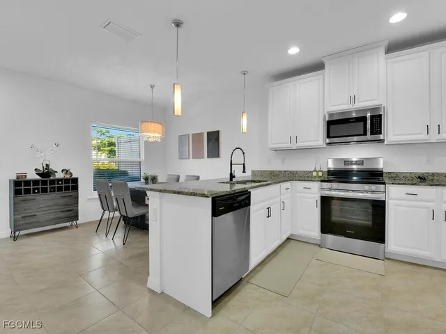 a kitchen with granite countertop cabinets and chairs
