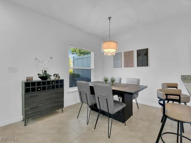 a view of a dining room and livingroom with furniture wooden floor a rug and a chandelier