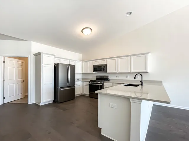 a kitchen with stainless steel appliances granite countertop a refrigerator a stove top oven a sink and dishwasher