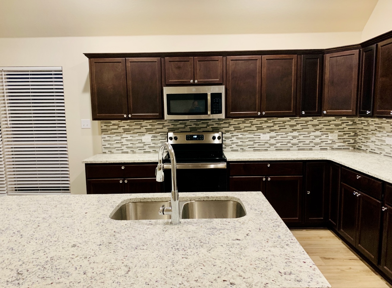 808 Fallbrook Drive Temple, TX 76502 - Photo 5 of 36 Kitchen with stainless steel appliances, dark brown cabinetry, and light stone counters