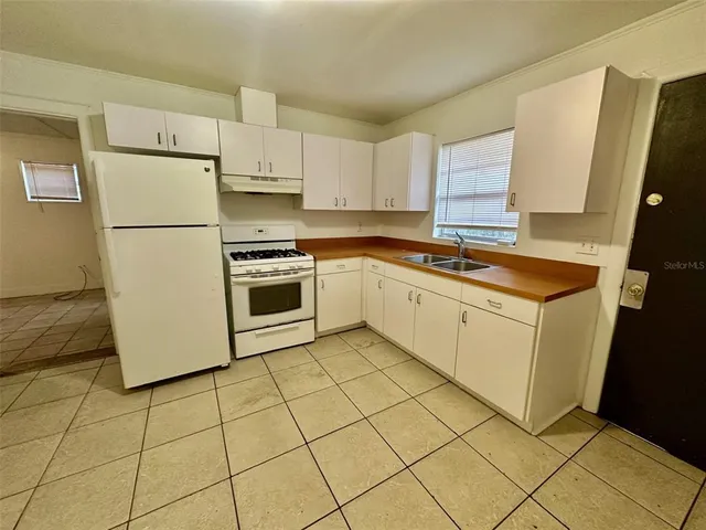 a kitchen with a stove a sink and a refrigerator
