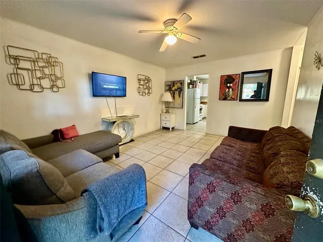 a living room with couches a couch and dresser with wooden floor