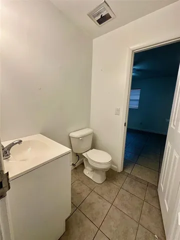 a white toilet sitting next to a white sink and vanity