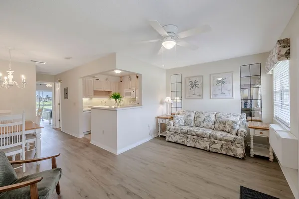 a living room with furniture and a dining table with wooden floor