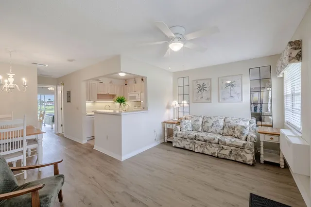 a living room with furniture and a dining table with wooden floor