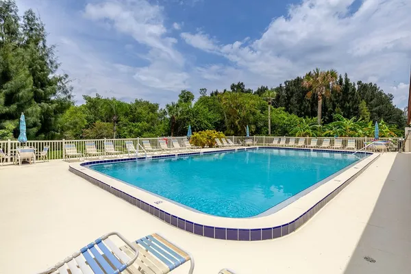 a view of a swimming pool with a chair and tables