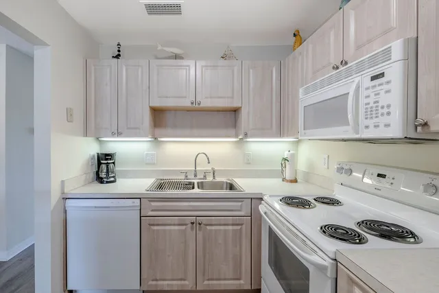 a kitchen with stainless steel appliances granite countertop a sink stove refrigerator and cabinets