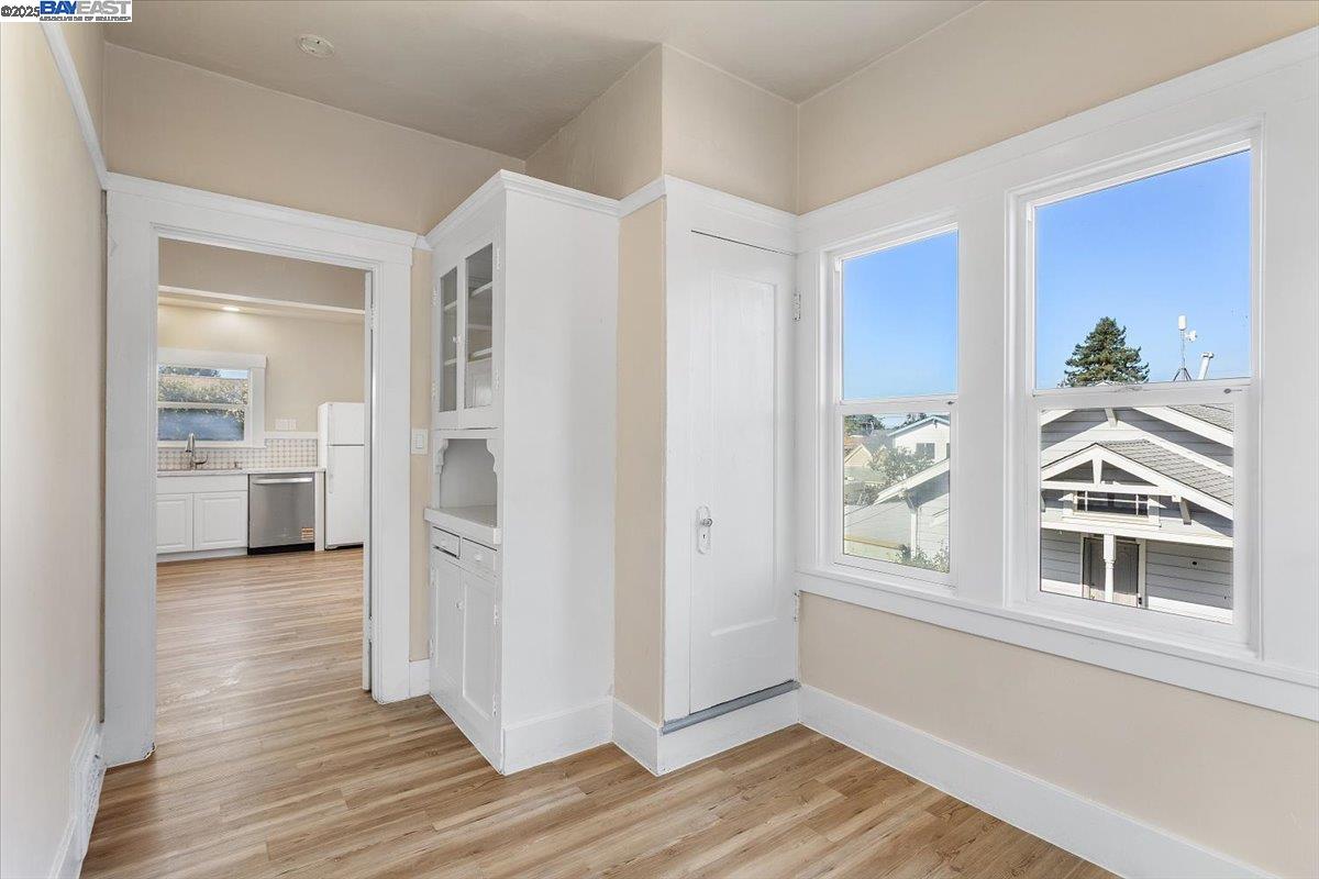 629 Santa Clara Avenue Alameda, CA 94501 - Photo 25 of 47 a view of a hallway with wooden floor and a kitchen
