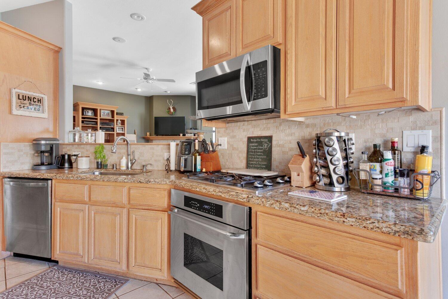 19510 Banducci Road Tehachapi, CA 93561 - Photo 22 of 75 a kitchen with stainless steel appliances granite countertop a stove a sink and a microwave