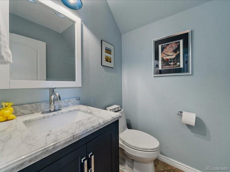 9306 Sulton Court Highlands Ranch, CO 80126 - Photo 14 of 48 a bathroom with a granite countertop toilet sink and mirror