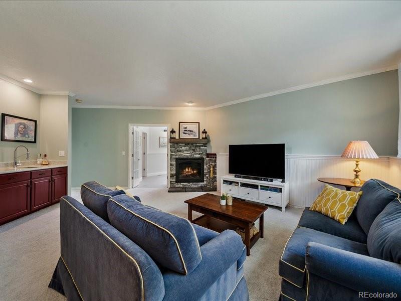 9306 Sulton Court Highlands Ranch, CO 80126 - Photo 29 of 48 a living room with furniture and a flat screen tv