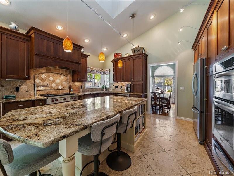 9306 Sulton Court Highlands Ranch, CO 80126 - Photo 10 of 48 a kitchen with granite countertop a stove a sink and a refrigerator