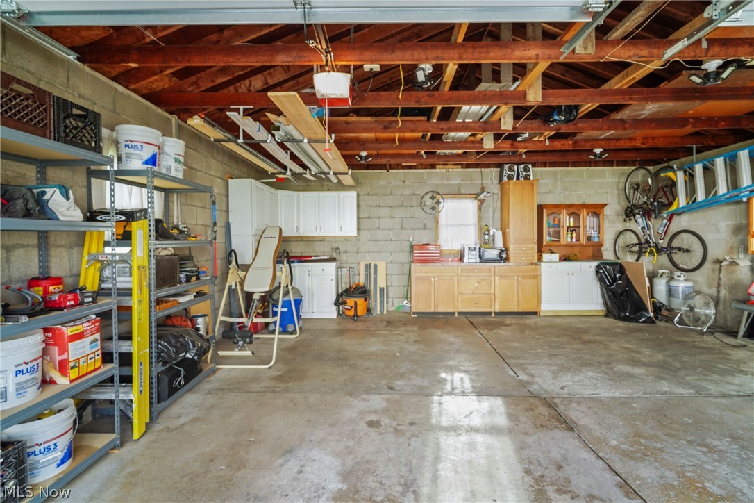 629 Clinton Street Niles, OH 44446 - Photo 44 of 50 Spacious garage featuring a concrete floor, exposed wood beam ceiling, block walls, and built-in cabinetry with ample storage