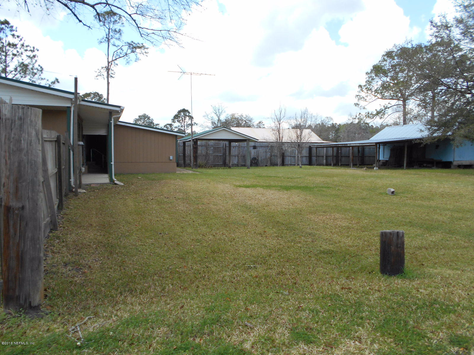 75179 Randy Road Yulee, FL 32097 - Photo 29 of 56 a view of a big yard with an house and wooden fence