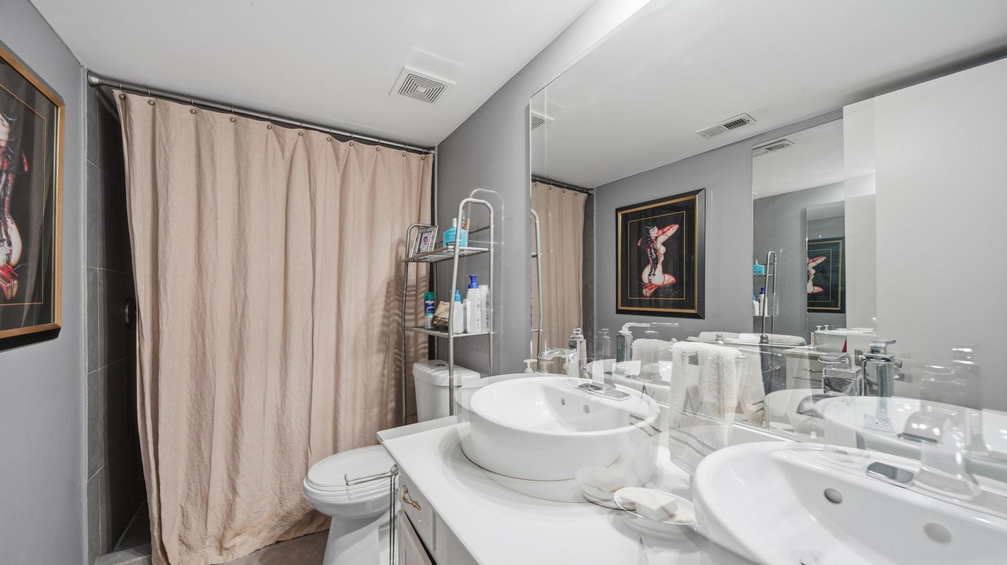 5866 Roxbury Drive, Unit 5866 Memphis, TN 38119 - Photo 14 of 20 Bathroom featuring a dual vanity with vessel sinks, a large wall-mounted mirror, and a shower area with a neutral-toned curtain
