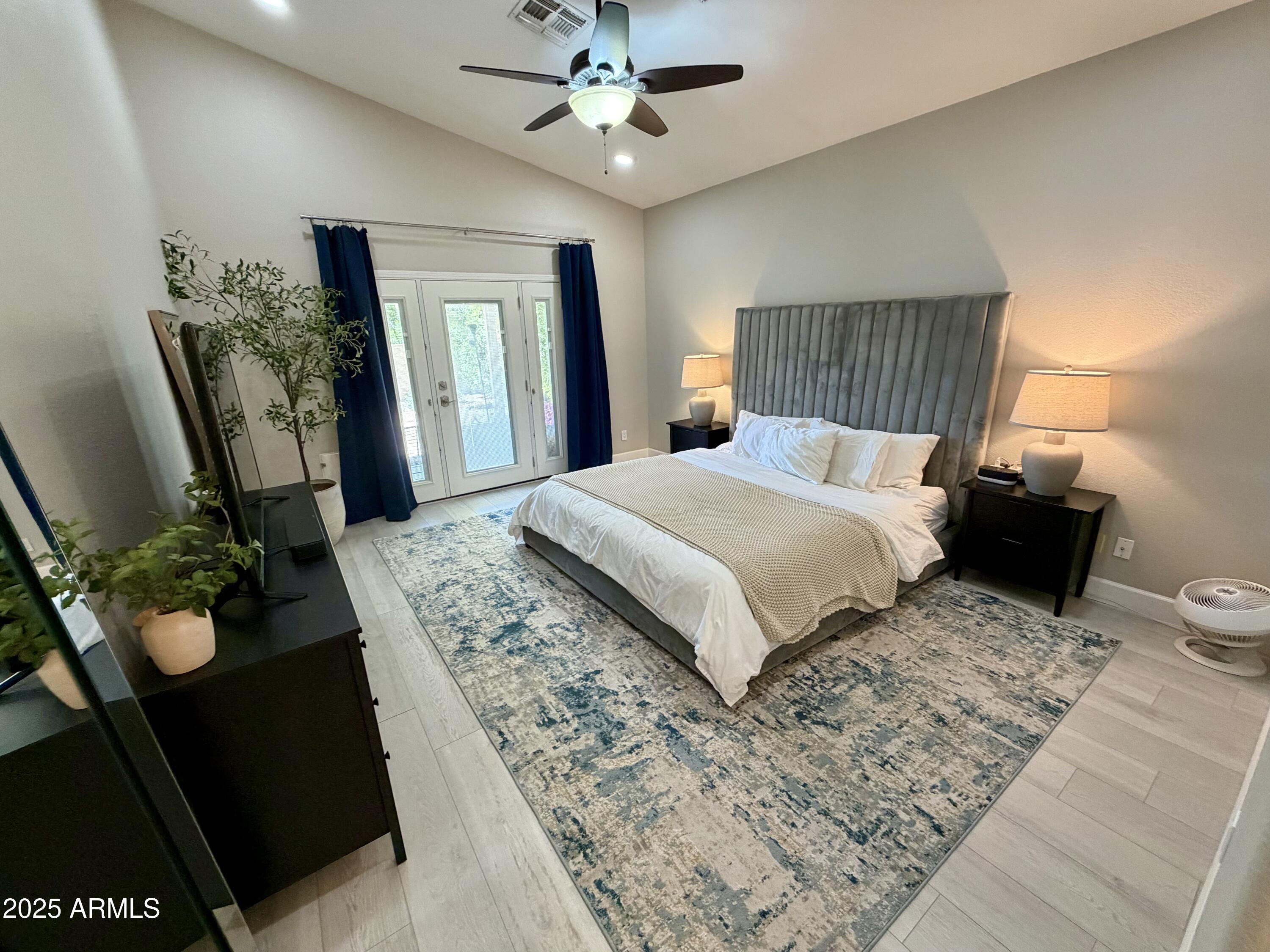 3068 North 83rd Place Scottsdale, AZ 85251 - Photo 32 of 46 a bedroom with a large bed and a chandelier