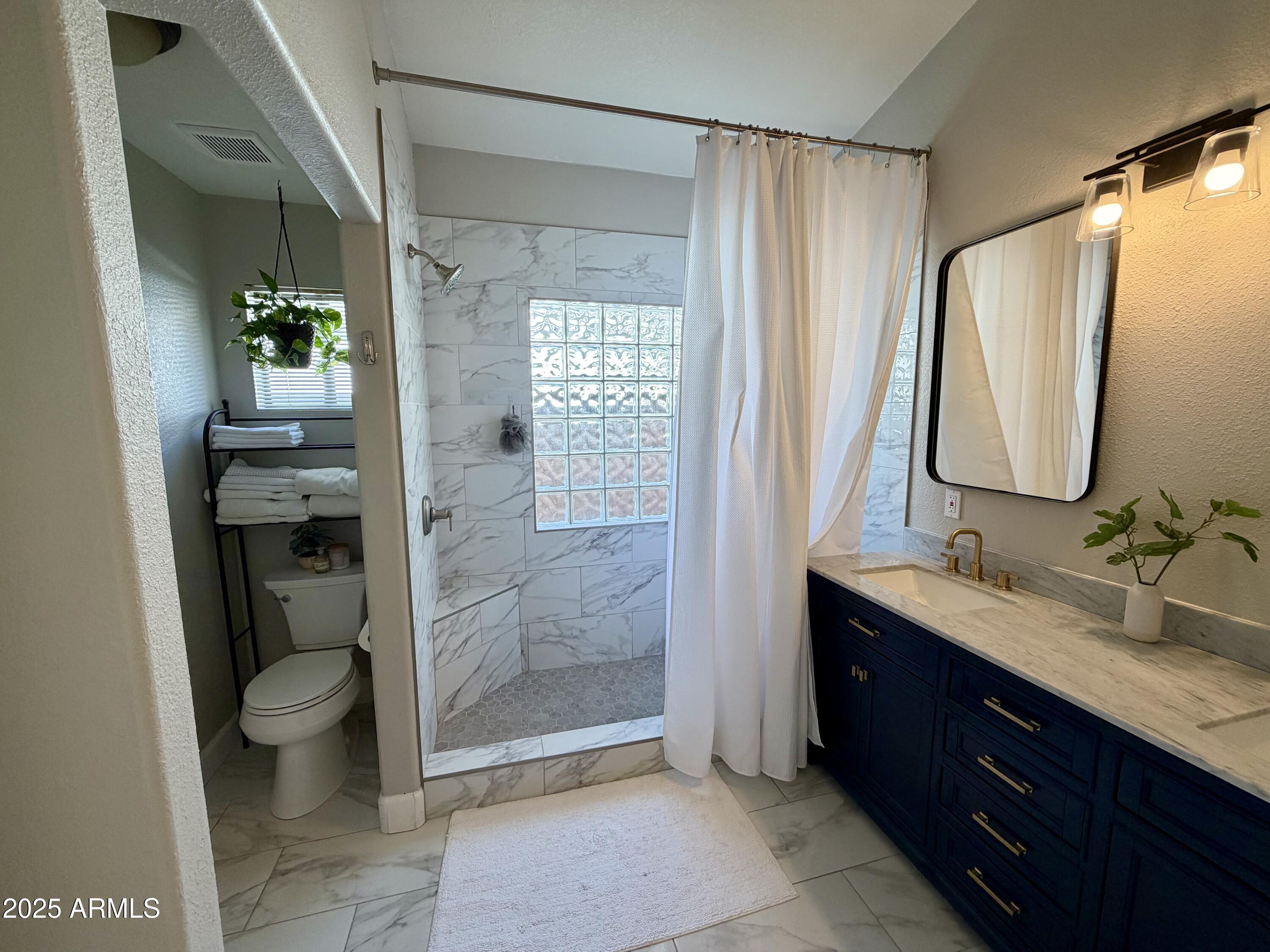 3068 North 83rd Place Scottsdale, AZ 85251 - Photo 35 of 46 a bathroom with a double vanity sink toilet and shower