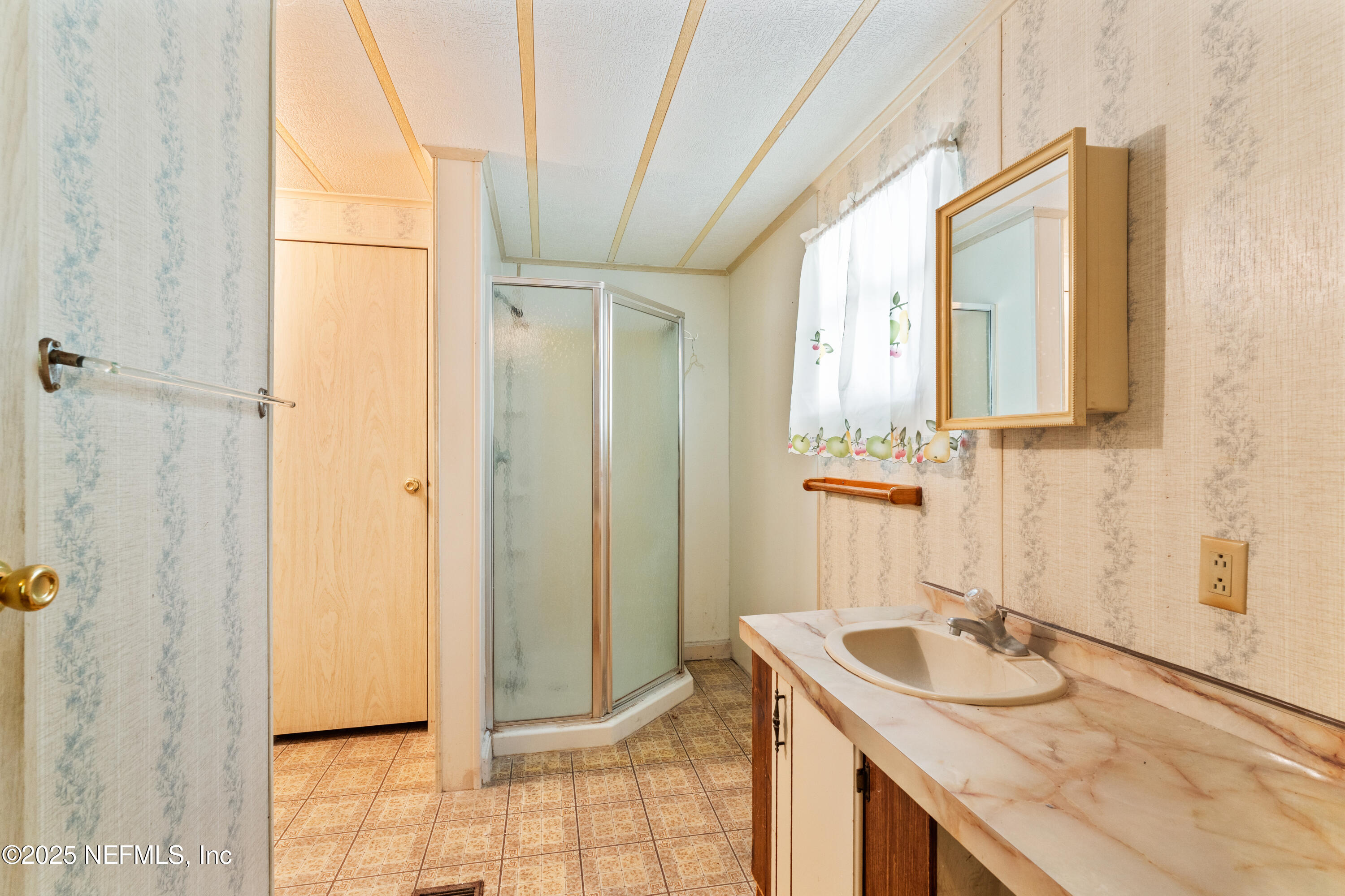 116 Iowa Street Crescent City, FL 32112 - Photo 11 of 25 a bathroom with a granite countertop sink a mirror and shower