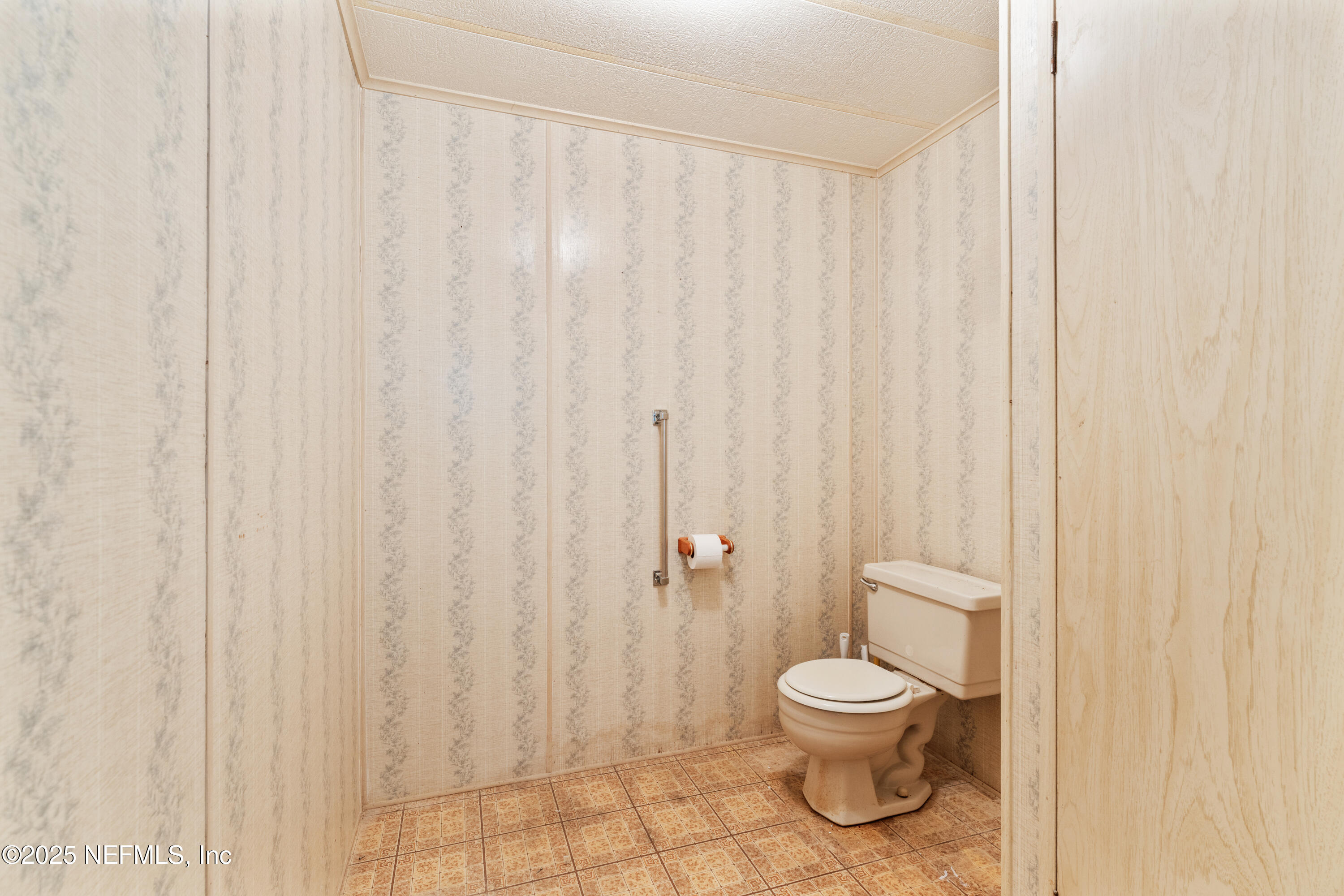 116 Iowa Street Crescent City, FL 32112 - Photo 12 of 25 a white toilet sitting next to a shower curtain