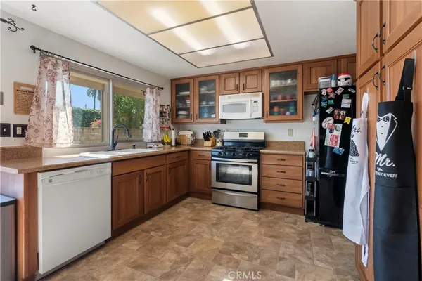 a kitchen with stainless steel appliances kitchen island granite countertop a refrigerator and a sink