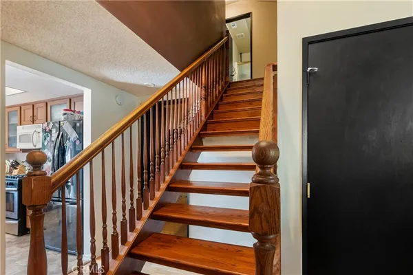 a view of staircase with wooden floor and white walls